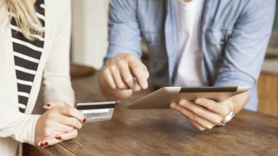 Someone paying with card on a tablet