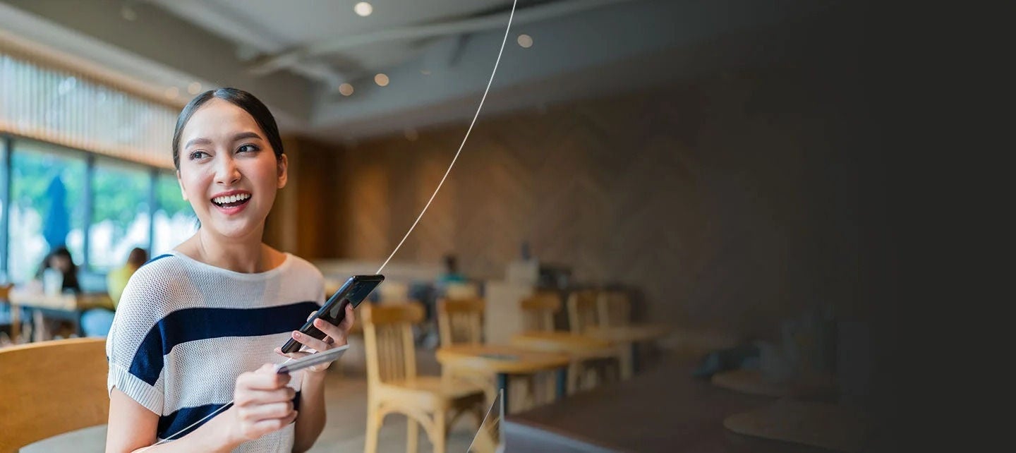 נשים מחזיקות טלפון ביד אחת וכרטיס תשלום ביד השנייה.