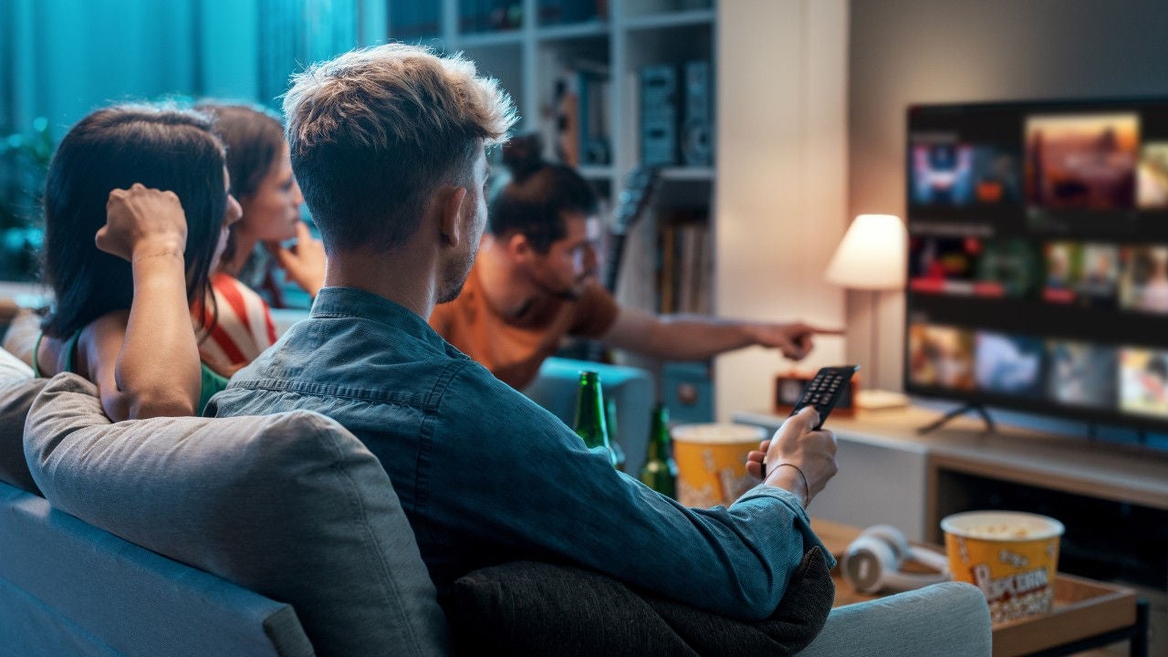 A group of friends watch TV together.