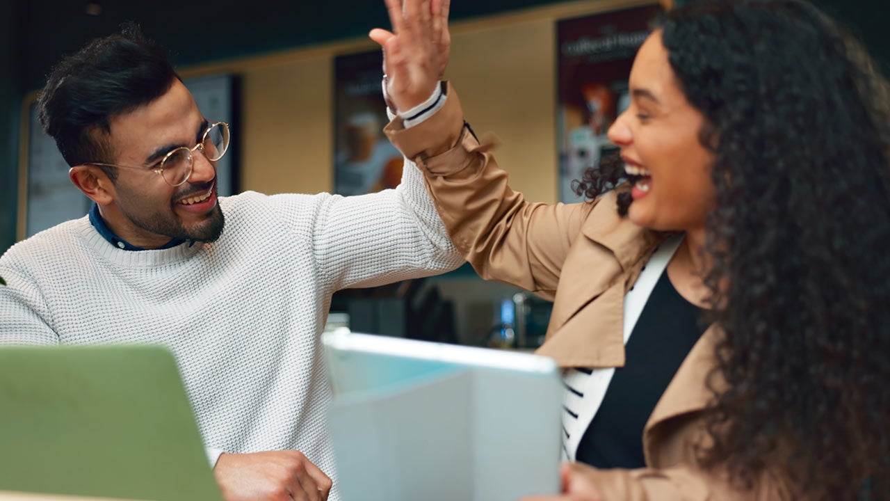 Two colleagues celebrating with high five.