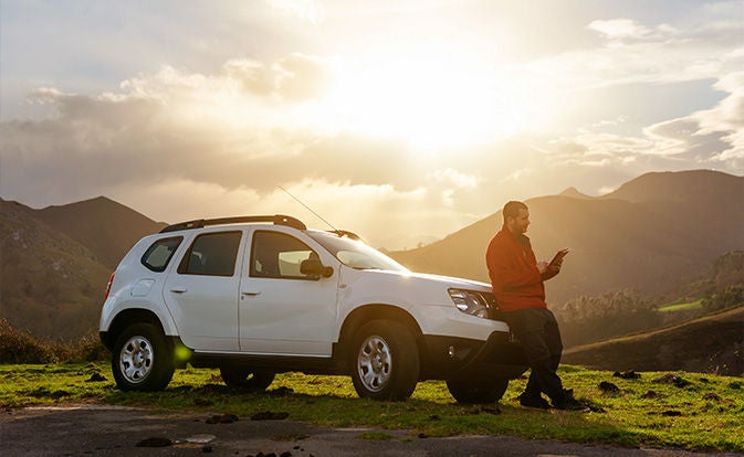 Man with off road car using digital tablet.