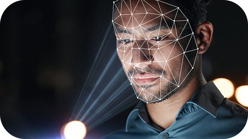 En mann er opplyst av et mykt, glødende lys, som skaper en slående kontrast mot den mørke bakgrunnen.