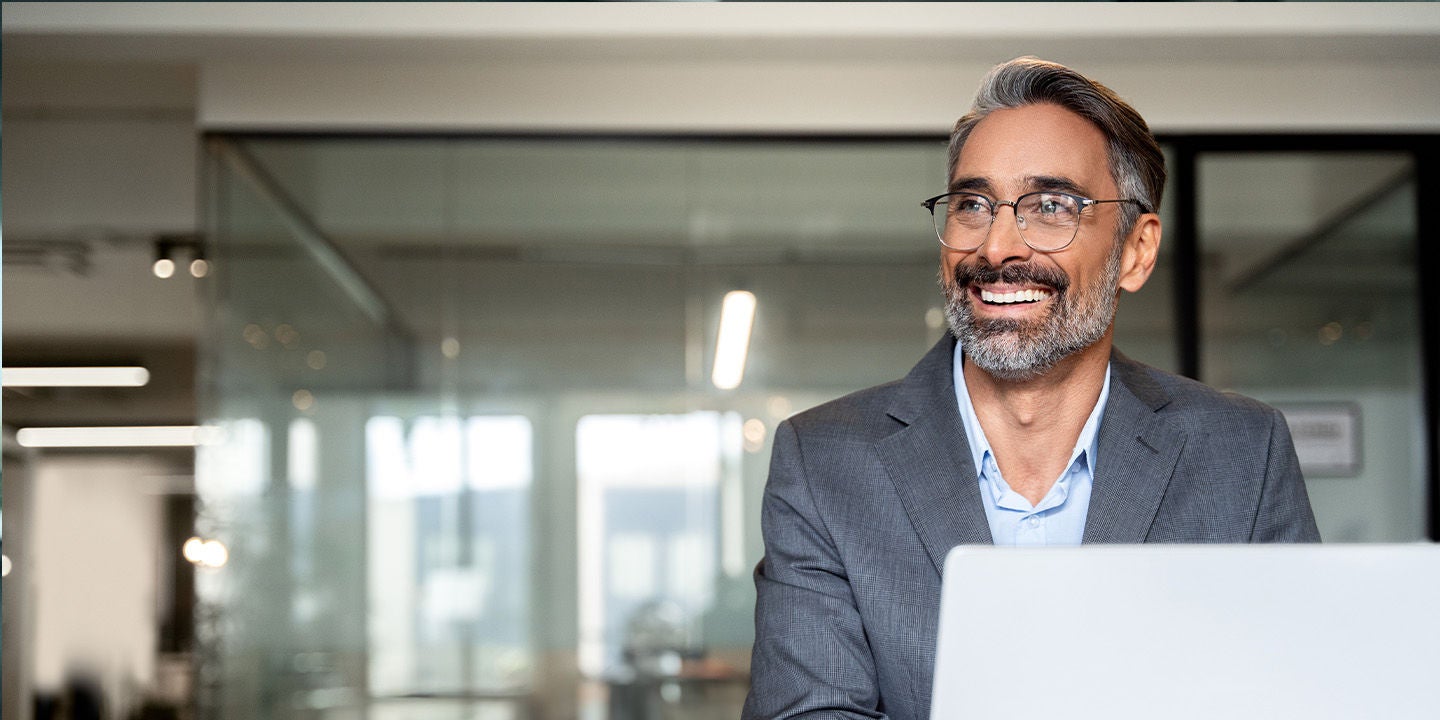 Smiling man wearing glasses working at the office