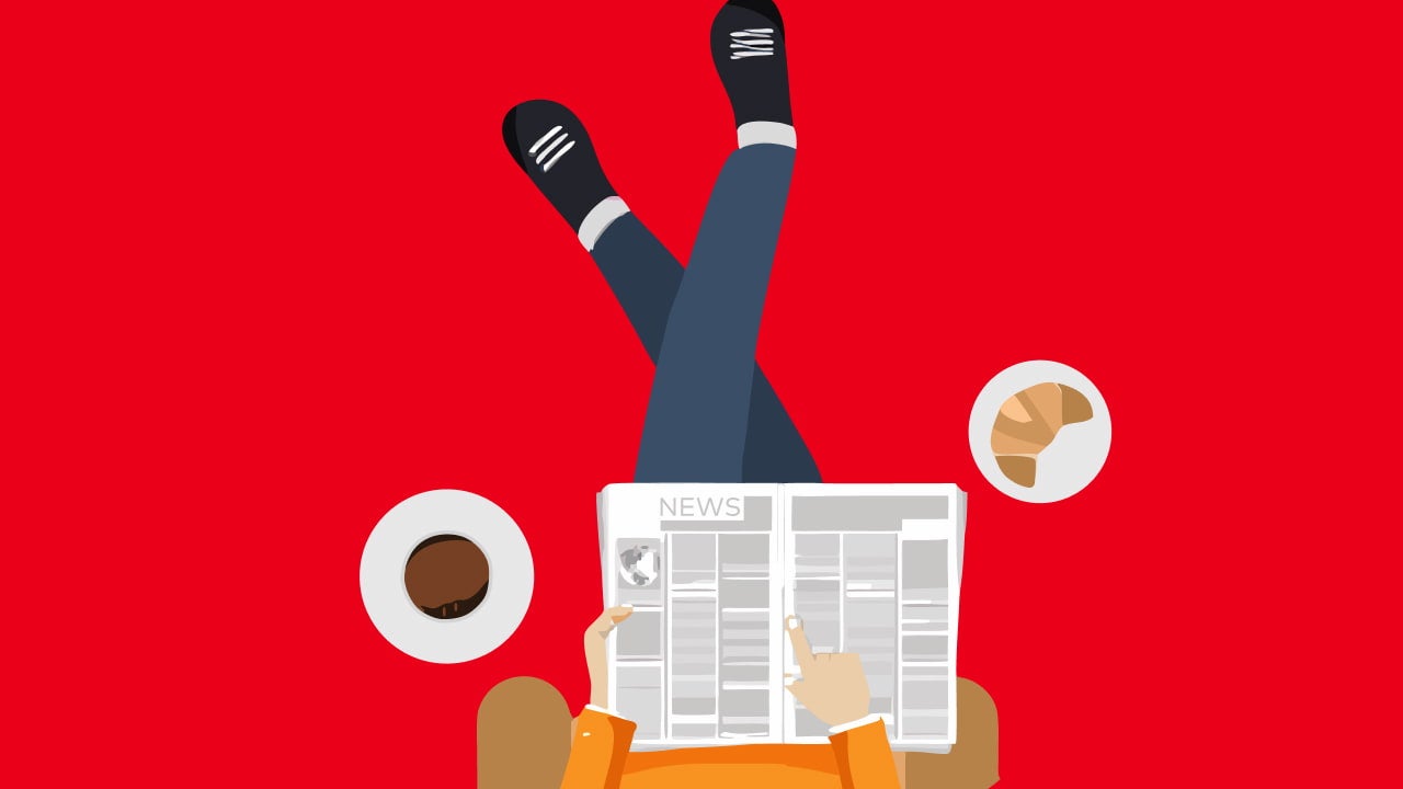 person reading newspaper with coffee croissant