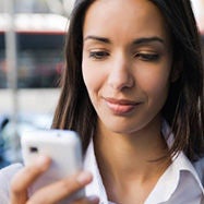 woman looking at phone smiling.