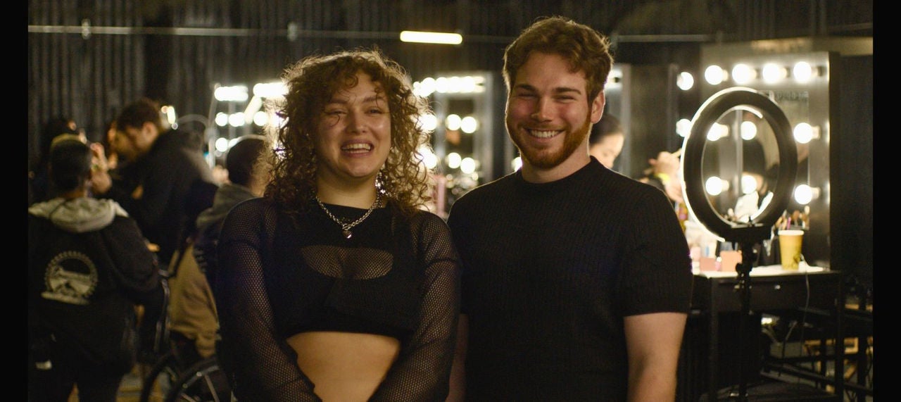 Hope Nestlehutt and Caleb Veitch smile in a dressing room.