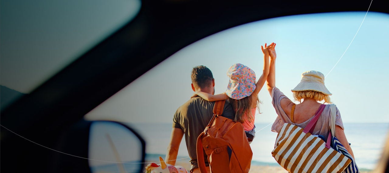 family walking toward sunny beach