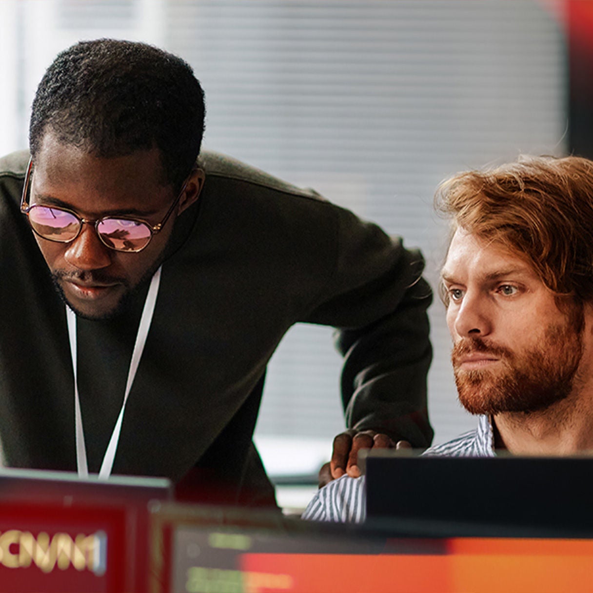 Man looking up surrounded by data on screens