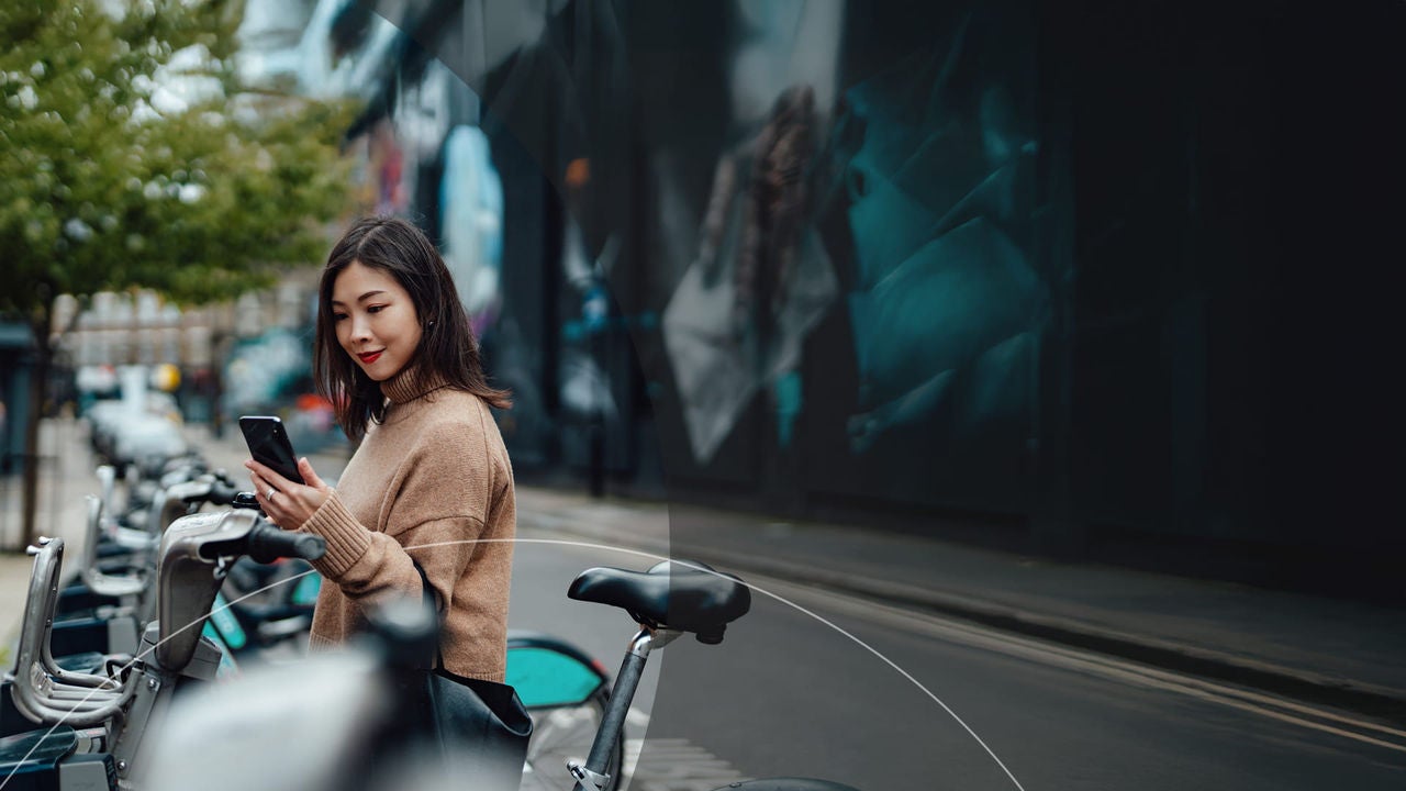 ניידות עירונית - אישה רוכבת על אופניים חשמליים במרחב העירוני.