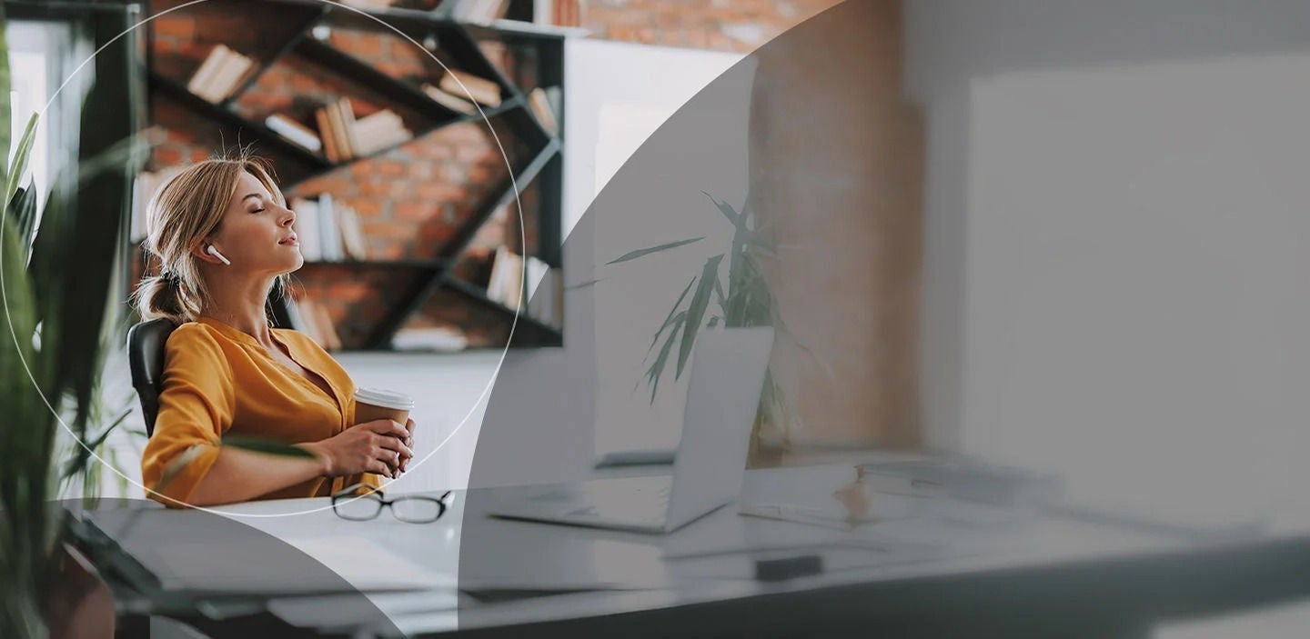 אישה נחה ליד שולחנה בעיניים עצומות, נהנית מרגע של שלווה.