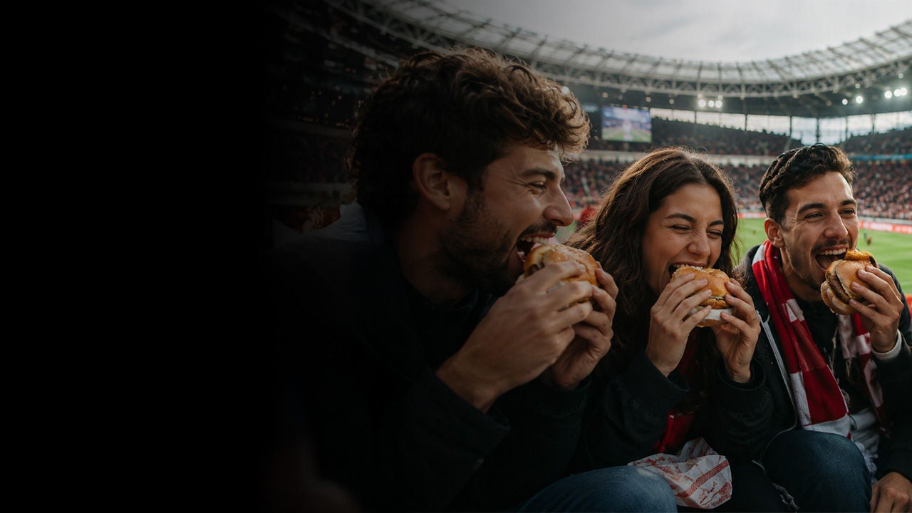 Two smiling people enjoying the benefits of being a Mastercard cardholder.