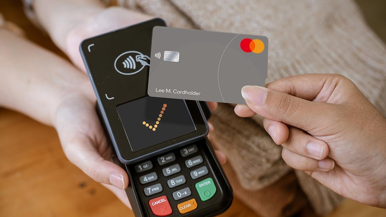 Tapping touch card on payment terminal in store.