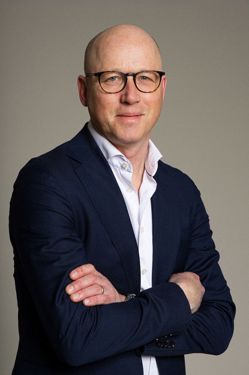 Portrett av Johan Modenius som står selvsikkert med armene i kors.