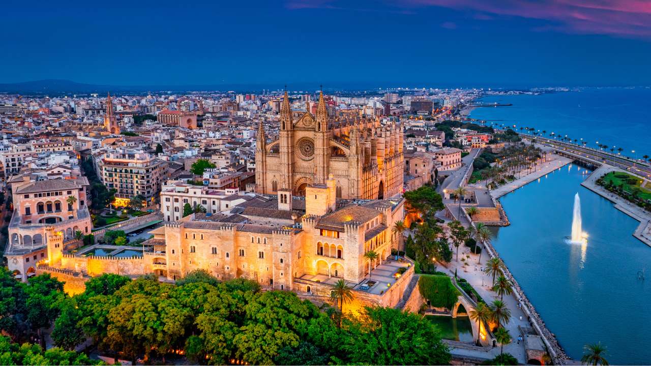 An aerial view of Palma de Mallorca and the Gaudi-restored cathedral at dusk. 