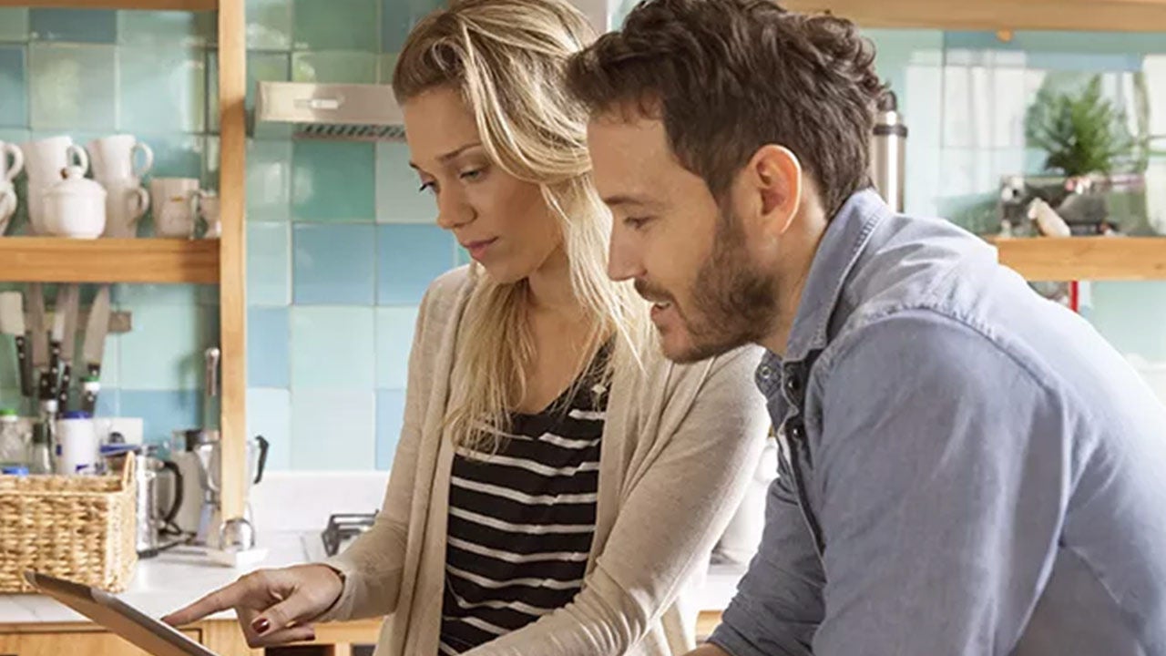 Two people looking at a device together.