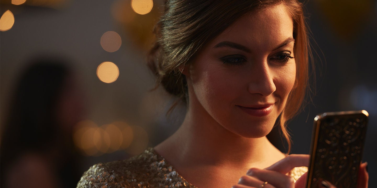 Elegant brunette woman holding smartphone smiling