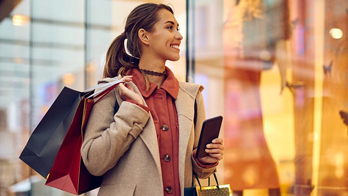 Woman with shopping bags gazing into a store window.