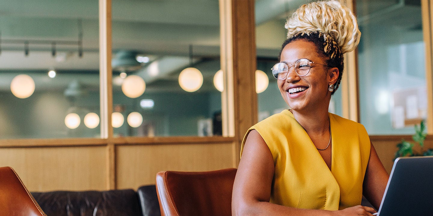 Woman in yellow shirt smiling at the office