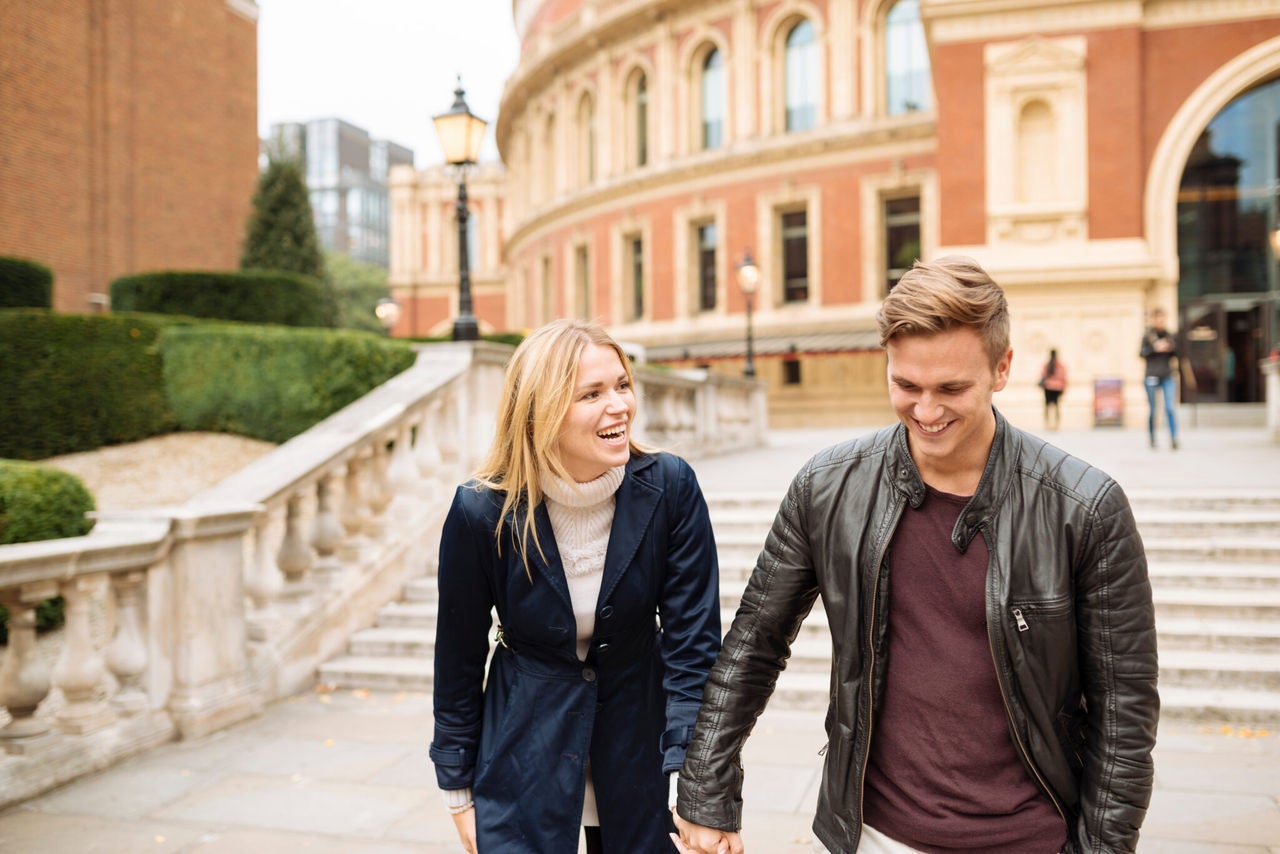 Man and woman holding hands in city
