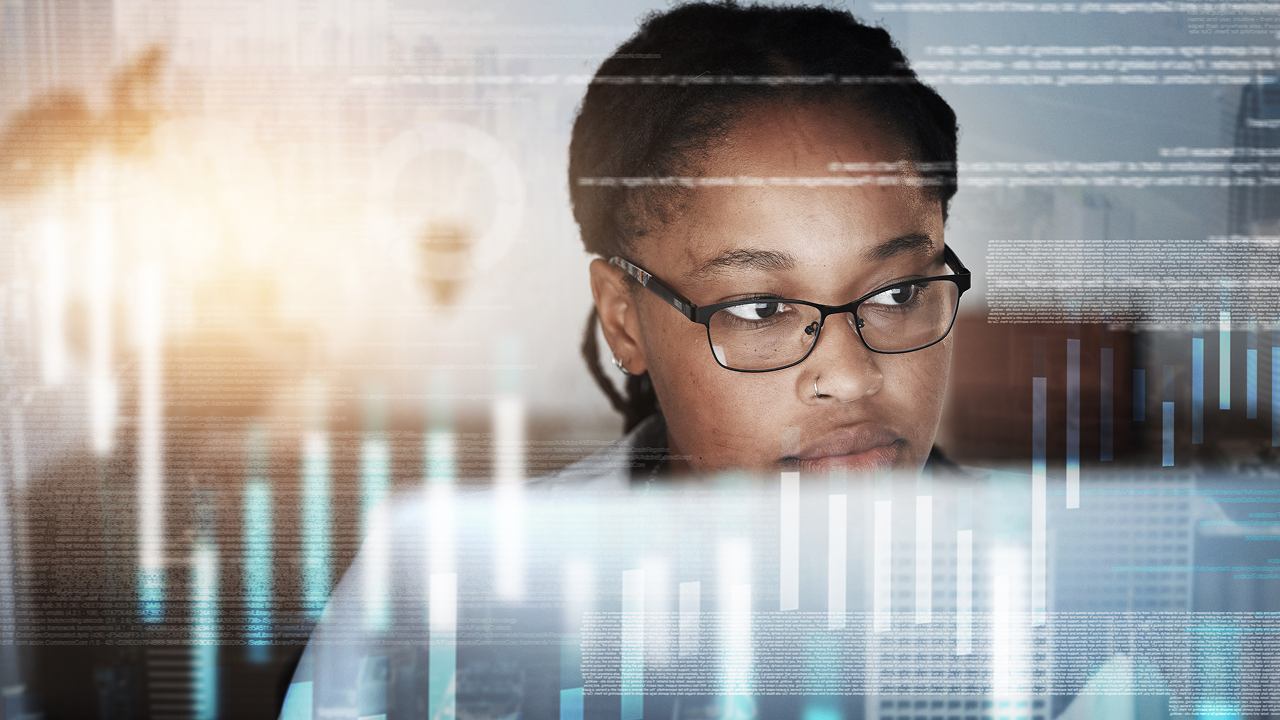 A woman with glasses looking at a computer screen 