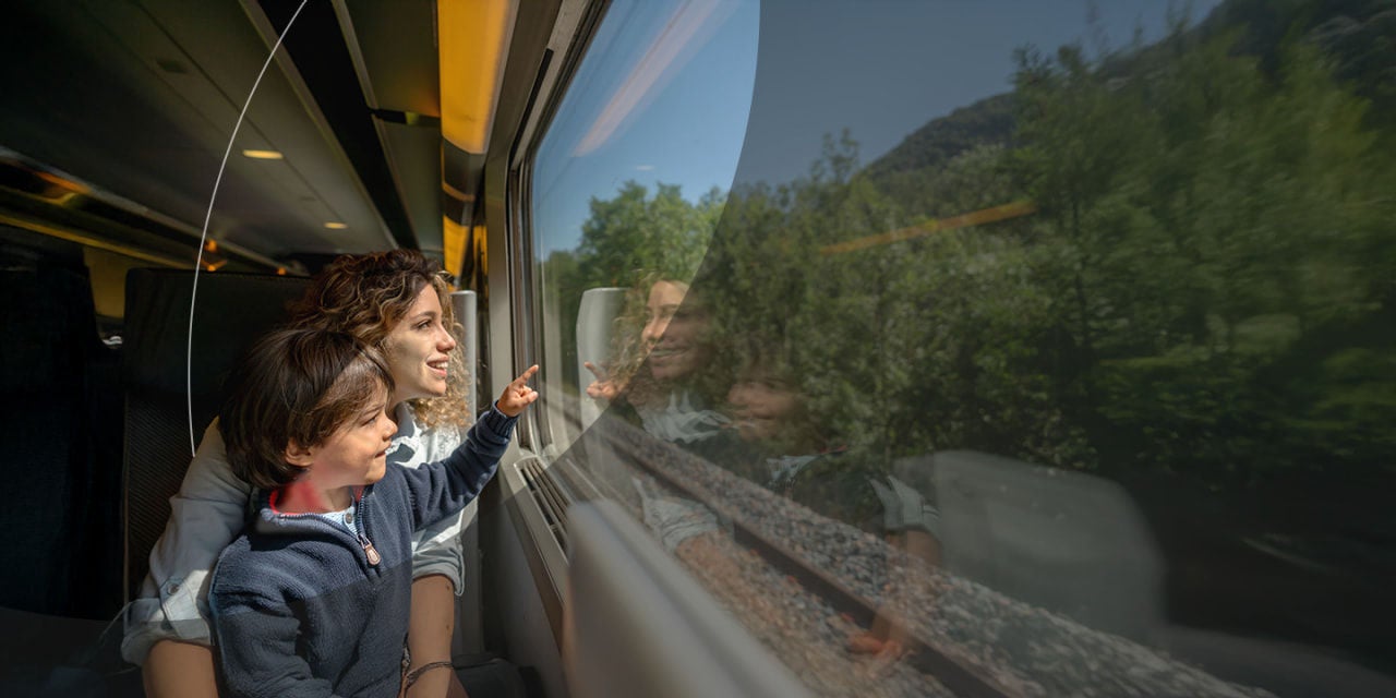 אישה וילדה במבט מבעד לחלון של רכבת.