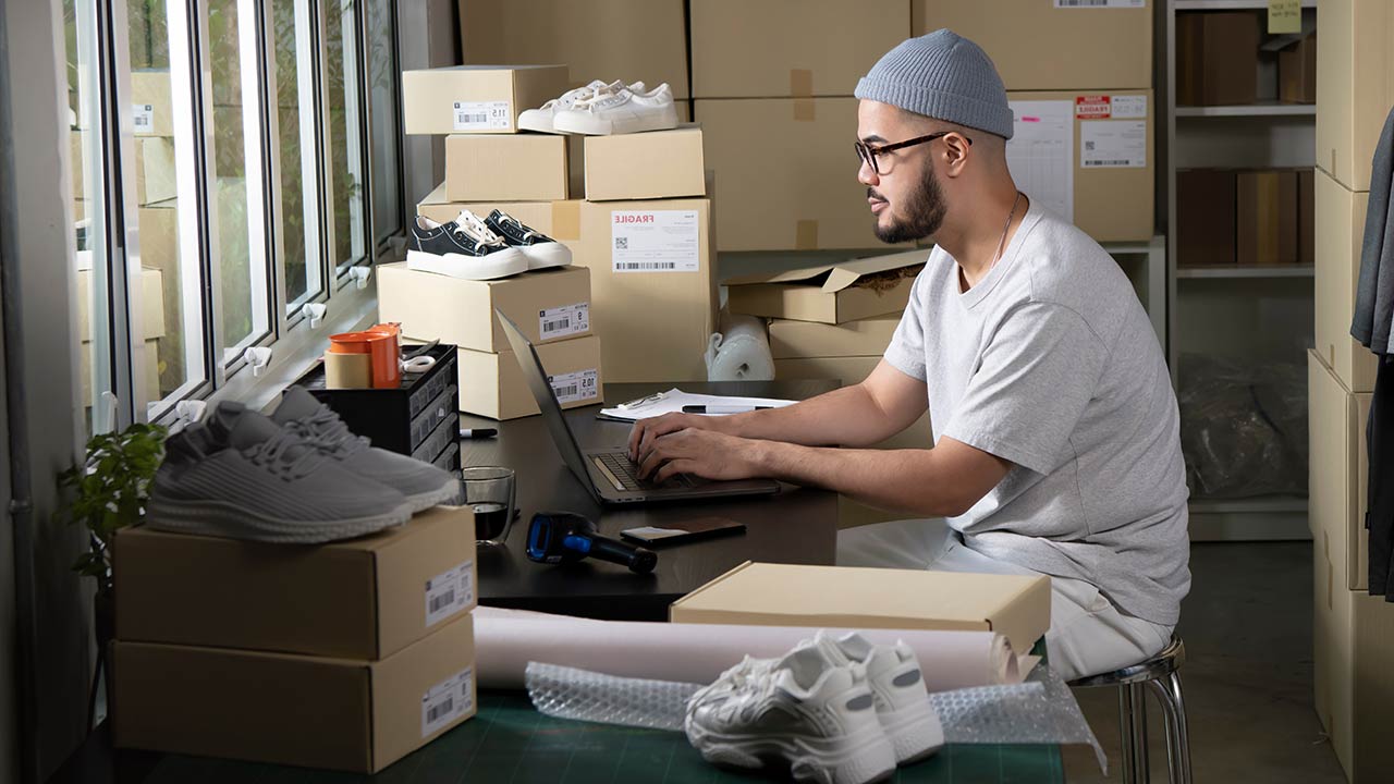 Online shoes seller confirming orders from customer on a laptop.