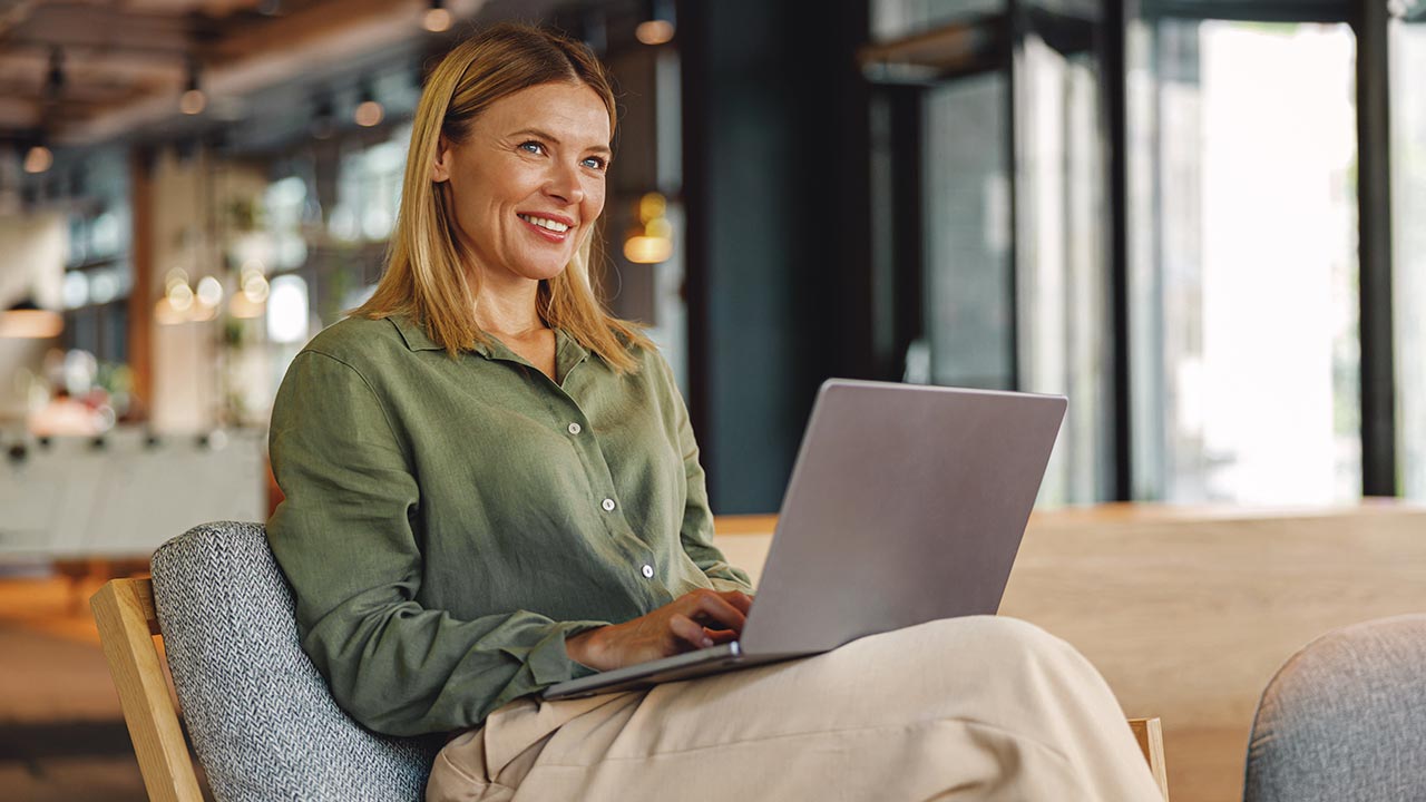 Professional woman with laptop in elegant workspace.