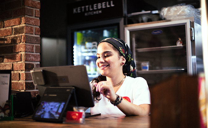woman working in retail standing at POS screen