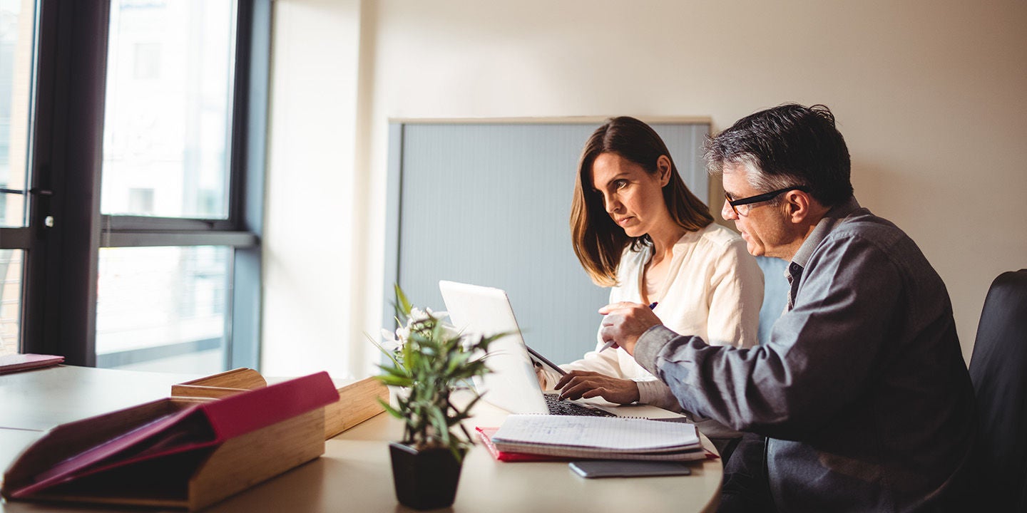 Coworkers using a laptop