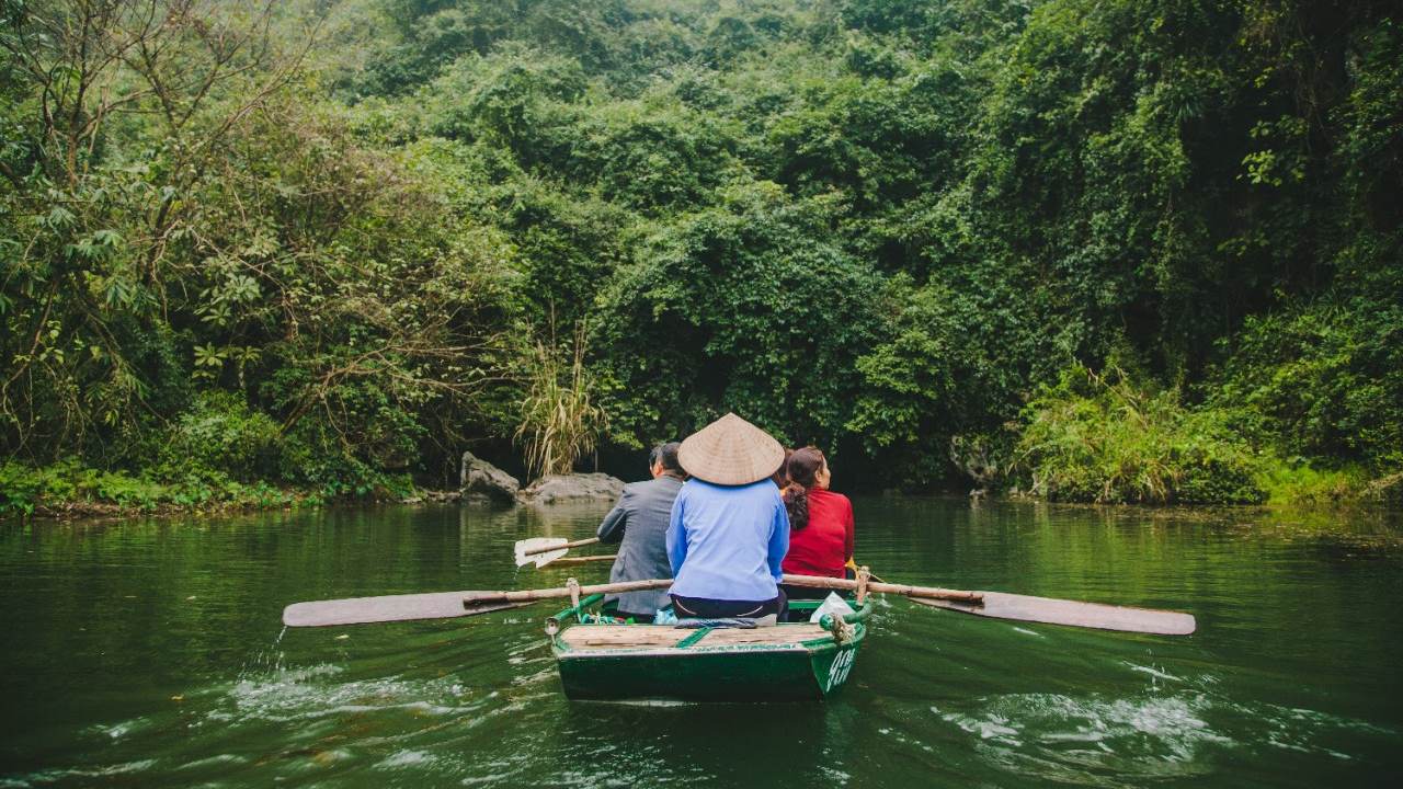 Two tourists take a boat ride on a river in Vietnam.