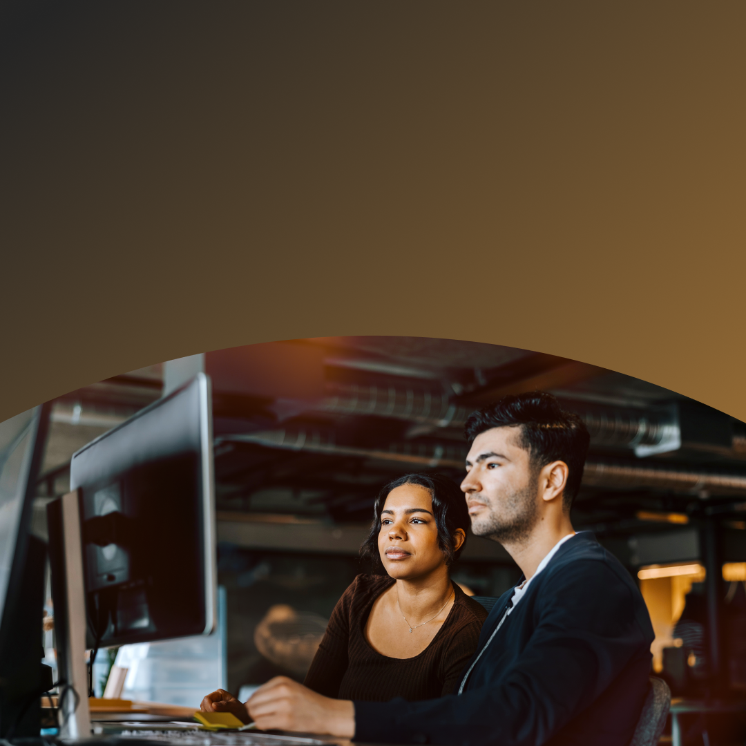 Two coworkers reviewing cyber fraud information on their computer
