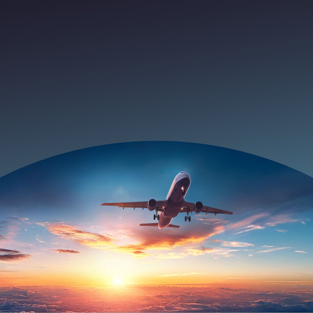 Avion décollant vers le coucher du soleil.