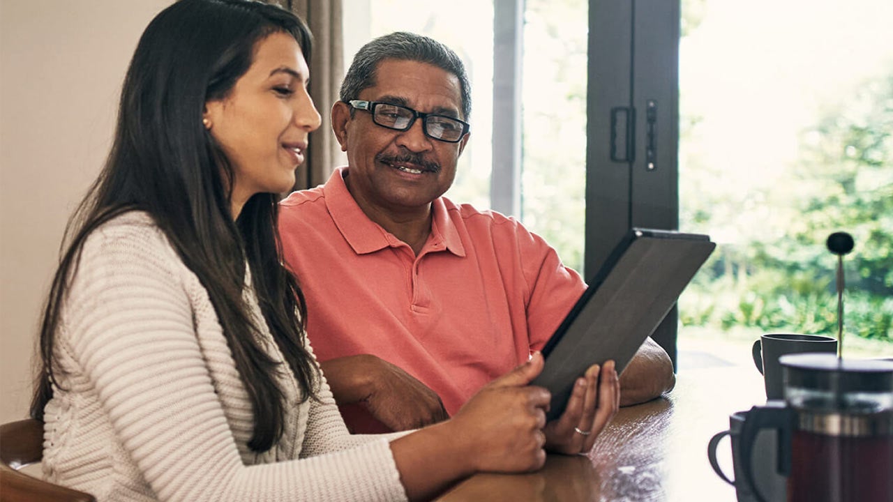 Woman man checking tablet in kitchen.