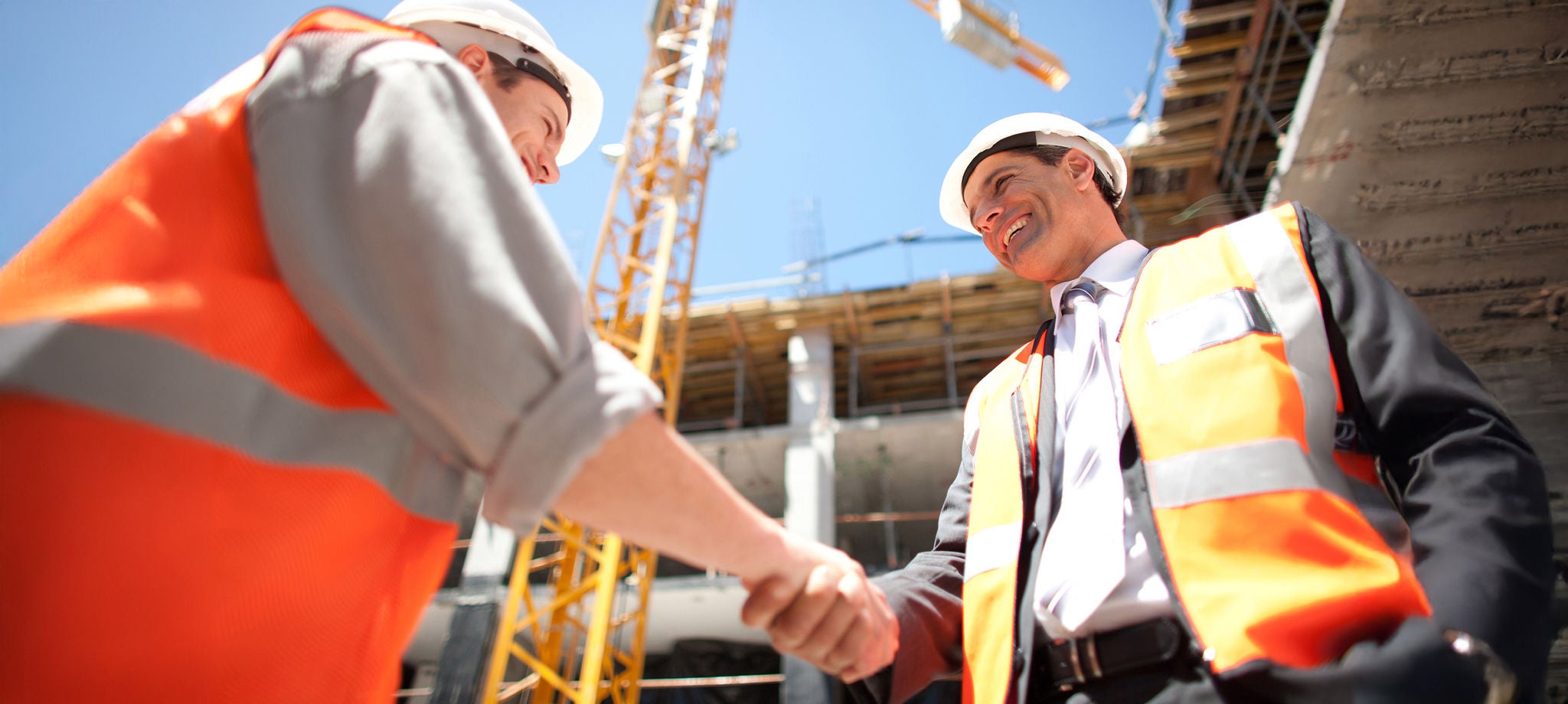 Pessoas em um canteiro de obras apertando as mãos