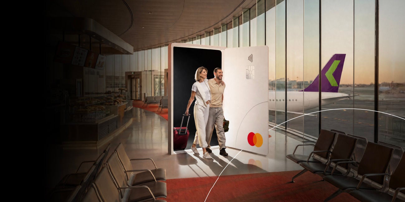Two smiling people enjoying the benefits of being a Mastercard cardholder.