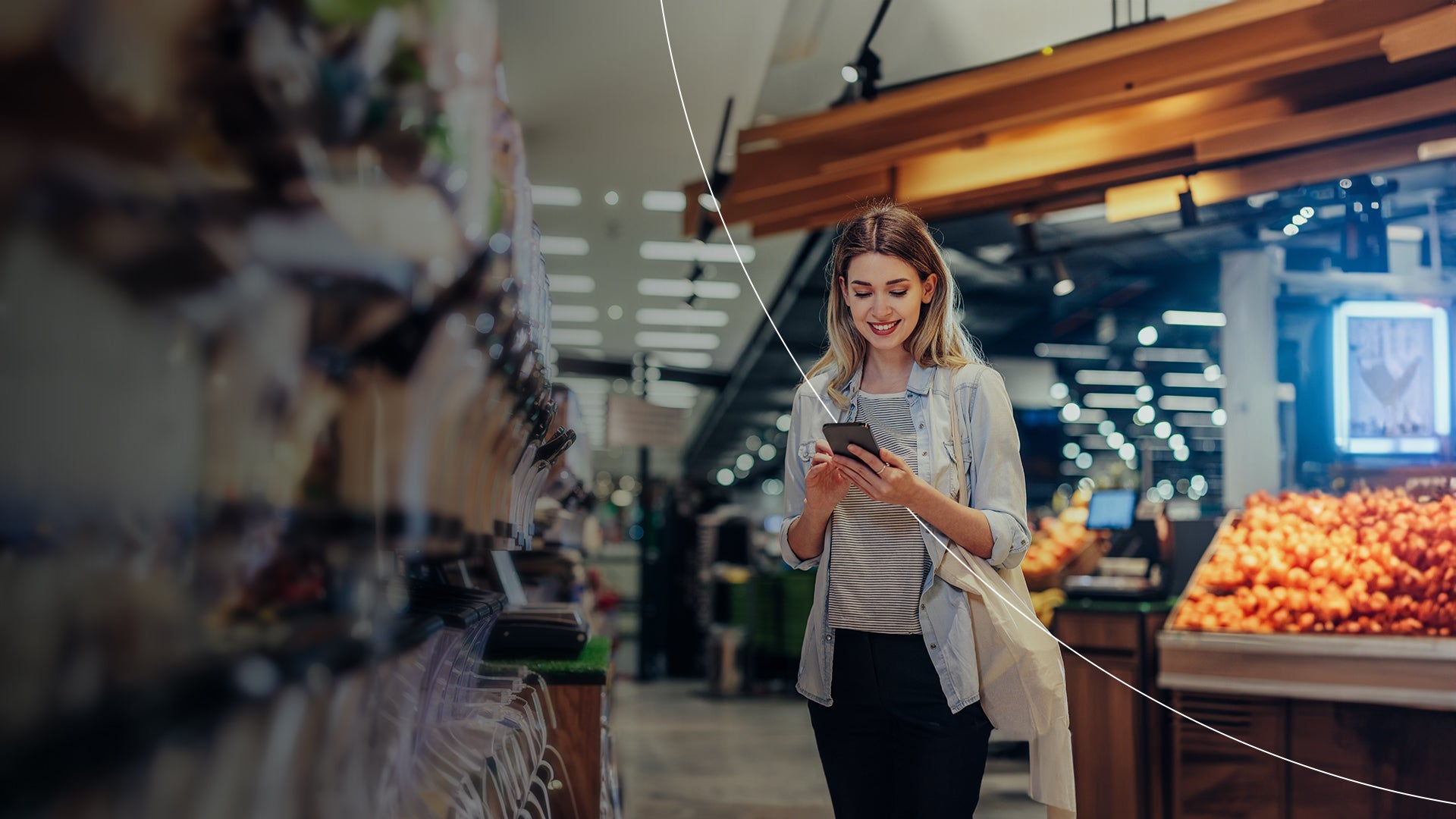 Woman looking at phone in grocery store