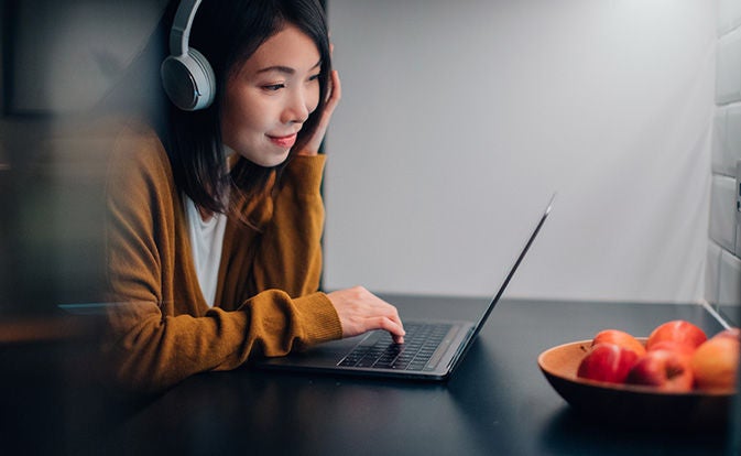Young woman with headphone using her laptop.