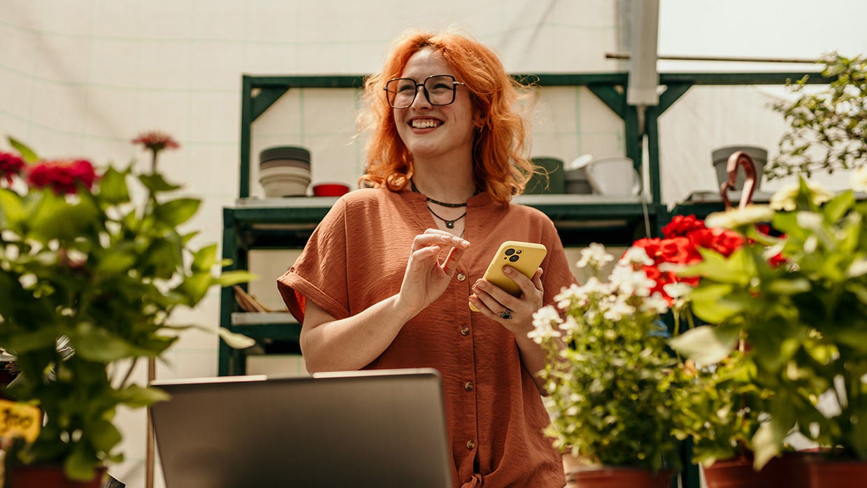 asian woman with orange hair using phone at nursery