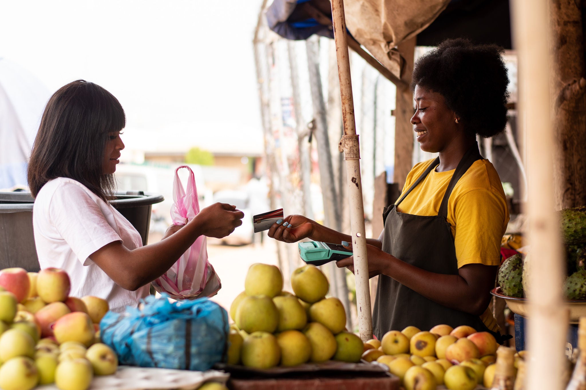Woman paying for fruit from vendor