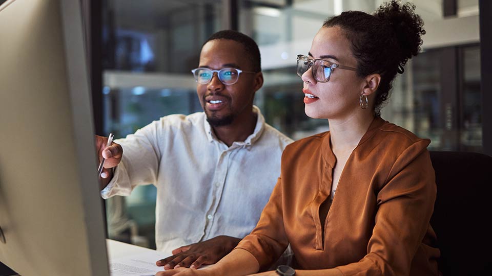 Two colleagues looking at a computer screen