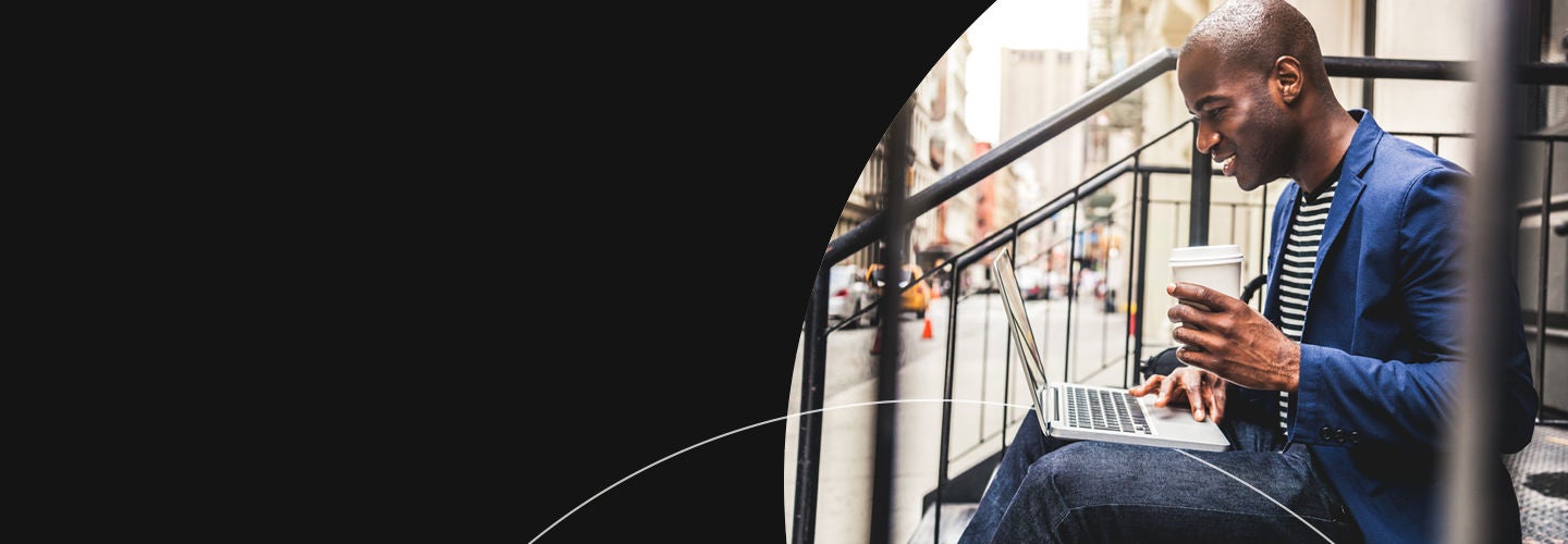 Man drinking a coffee working on his laptop outside