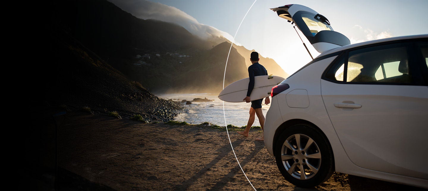 Samochod w kolorze białym, zaparkowany  na parkingu 