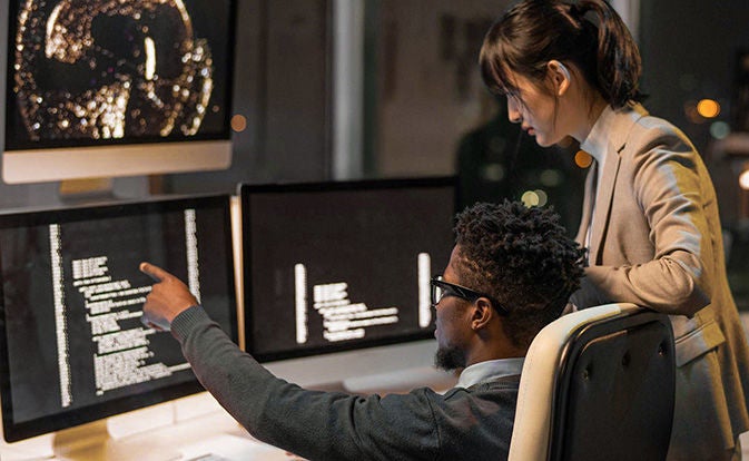 Person pointing to specific data on screens