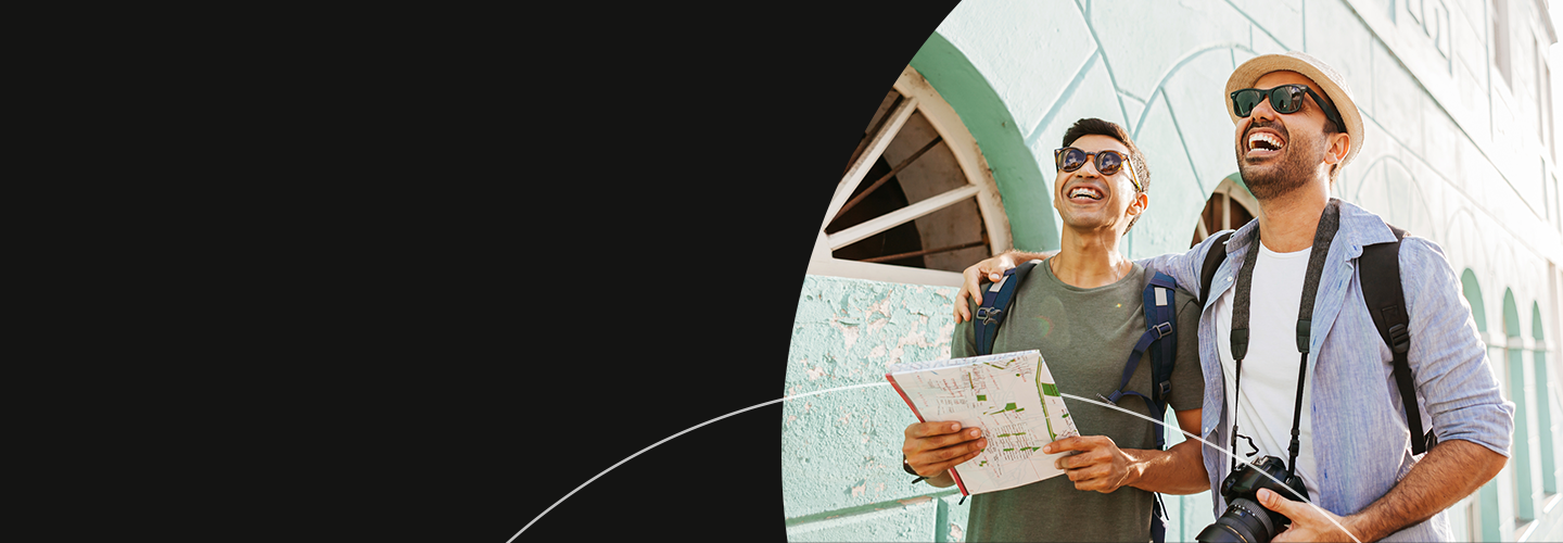 Two men walking in a city with a map and smiling