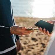 Customer using tap on phone at the beach.