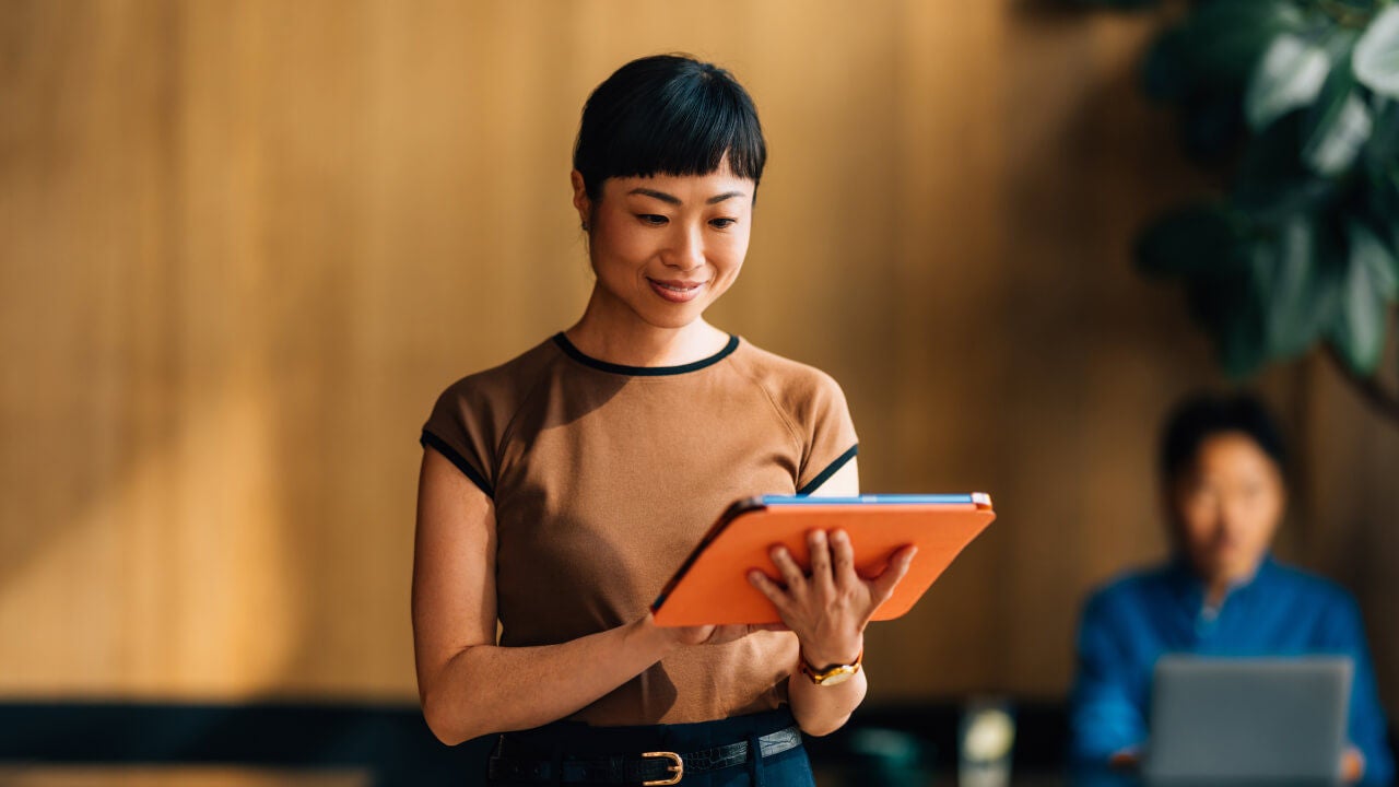 standing worker with orange tablet