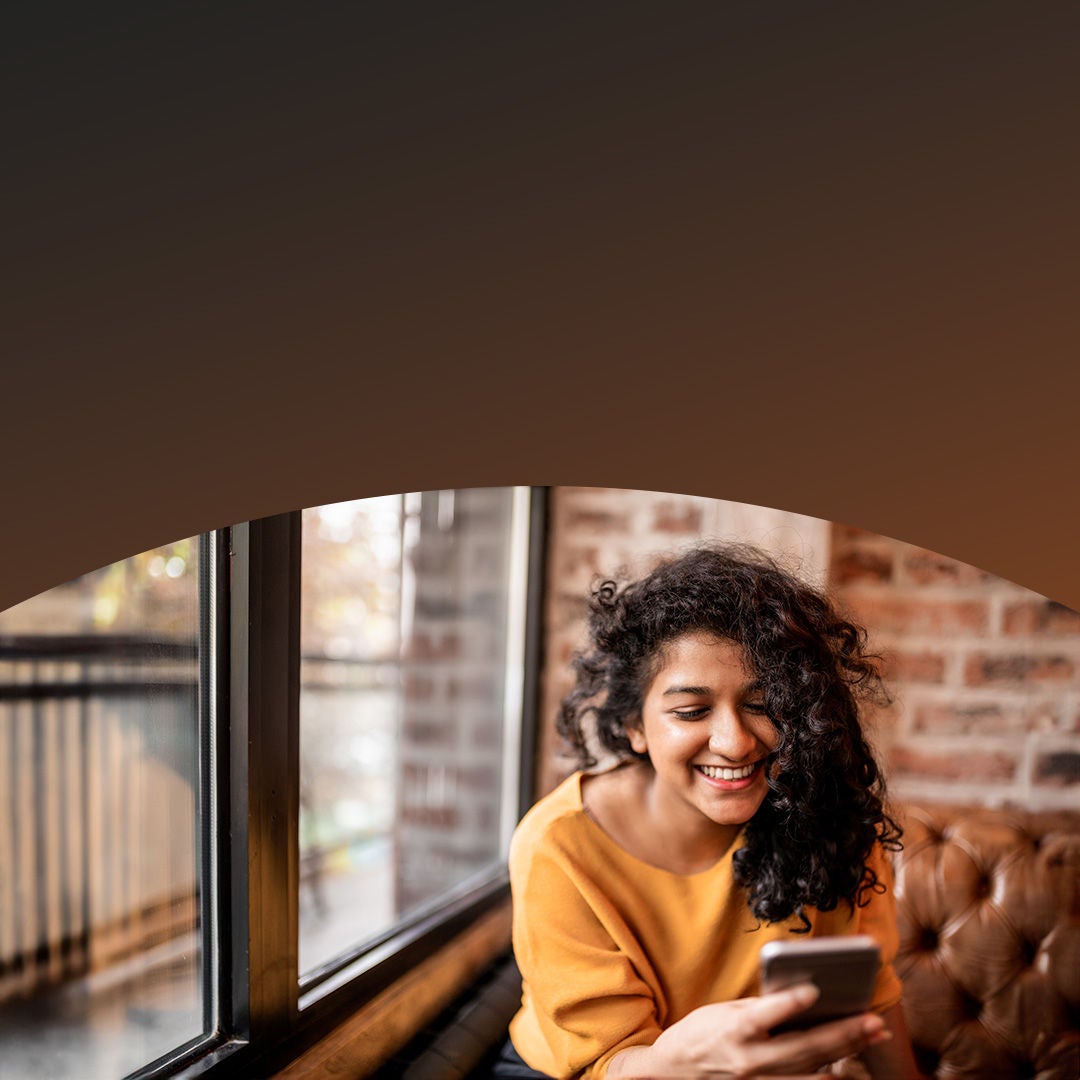 woman looking at the phone and smiling.