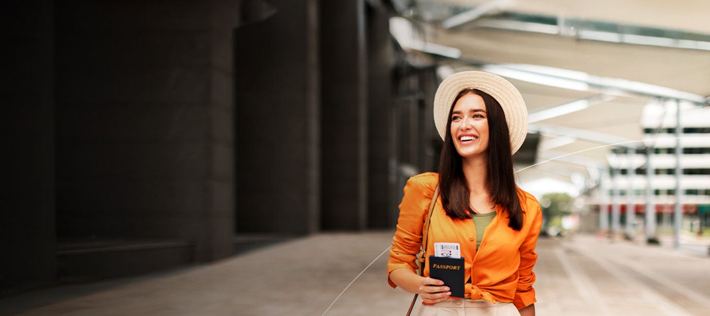 smiling woman holding passport and boarding pass