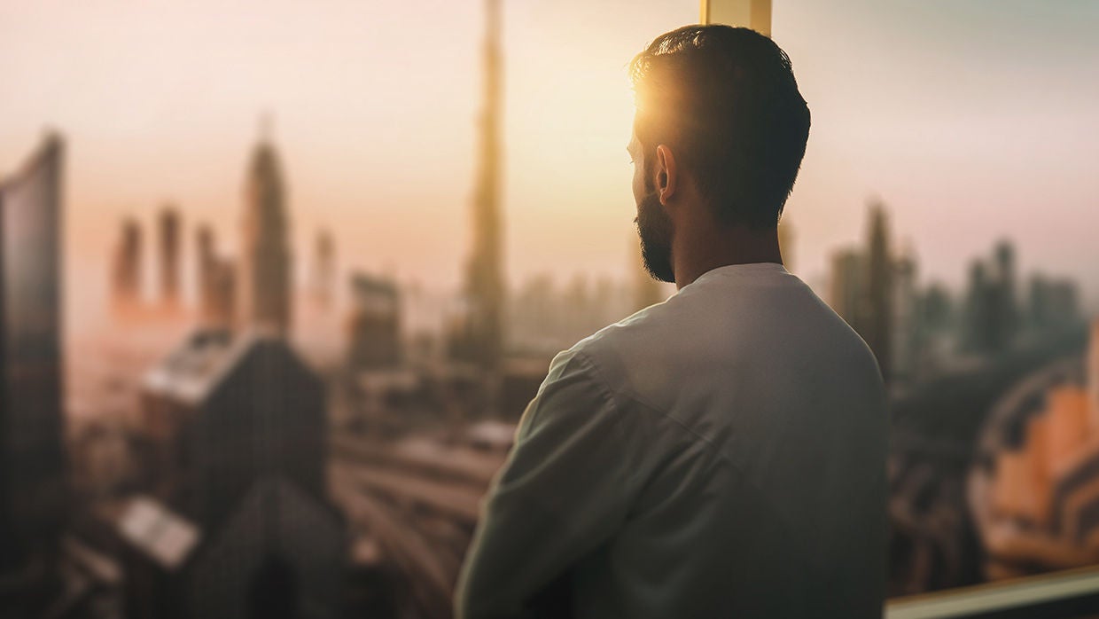 Arabic business man looking out through the office.
