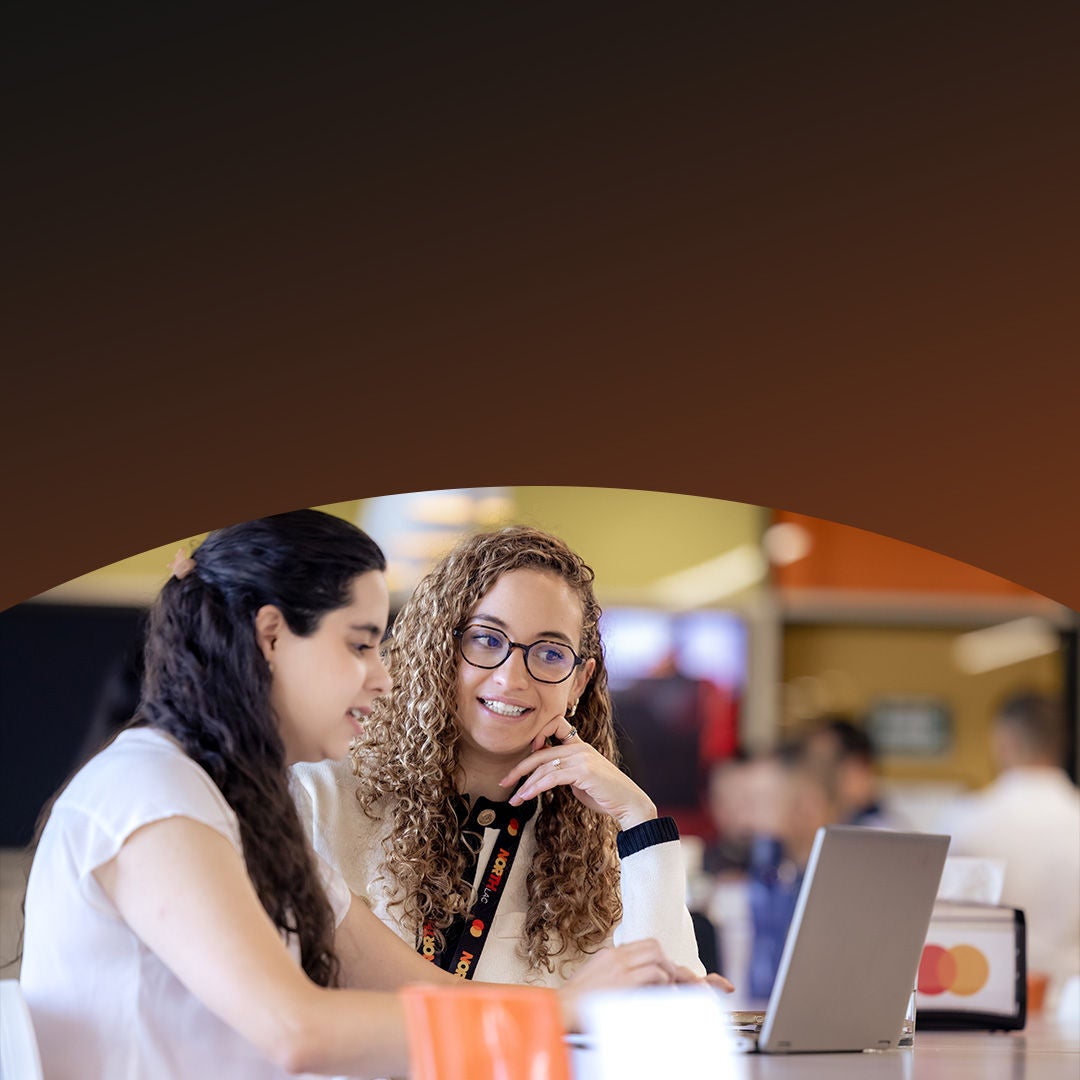 Two Mastercard colleagues working on laptop.